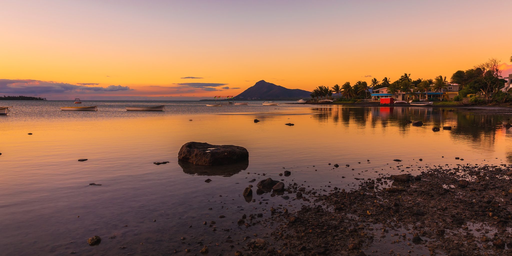 Ocean With Fishing Boats And Town At Sunset Time In Mauritius.